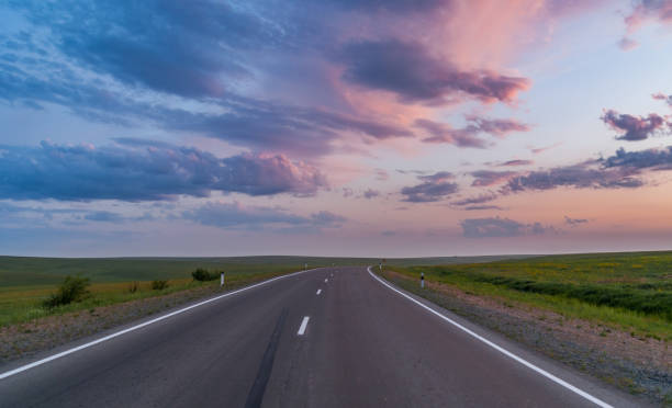 istock Empty asphalt road through the beautiful field on sunset 977279830