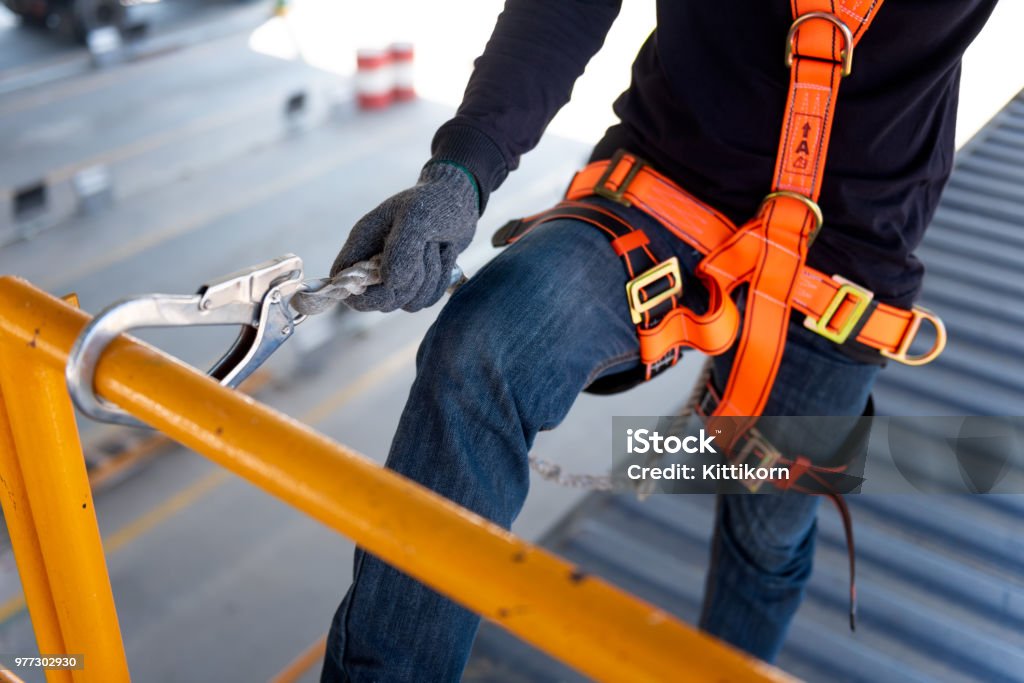 Construction worker use safety harness and safety line working on a new construction site project. Safety Stock Photo