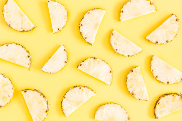 istock Pineapples on yellow background. Summer concept. Flat lay, top view 977307288