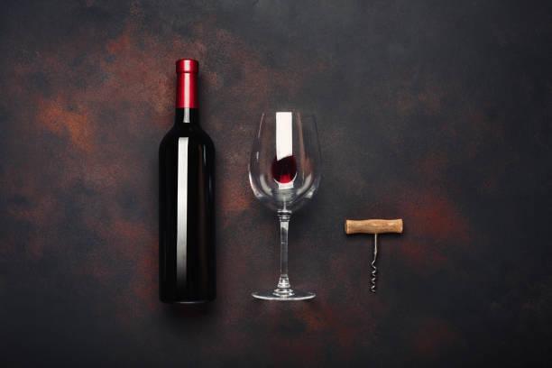 istock Bottle of wine, corkscrew and wineglass on rusty background 977323864