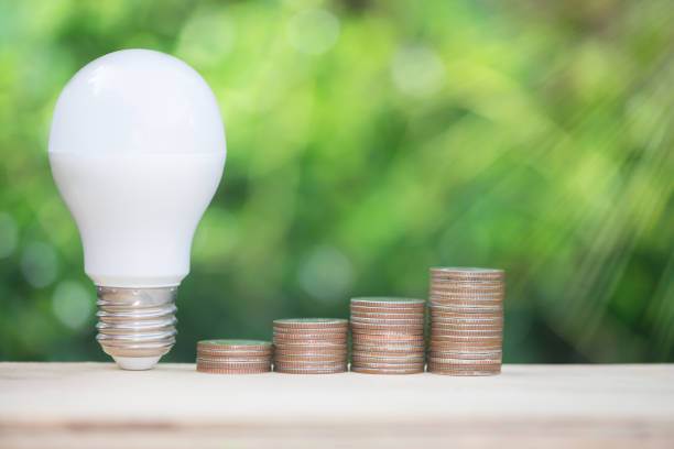 istock LED build and growing coins stack with sun lighting and green nature background for energy saving concept 977372156