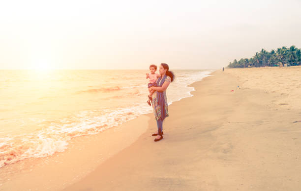 istock mother and daughter in beach 977401166