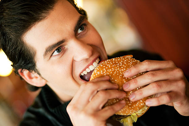 istock Man in restaurant about to take first bite of a hamburger 97740217