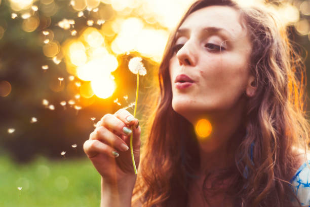 istock Young hippie woman blowing dandelion 977415342