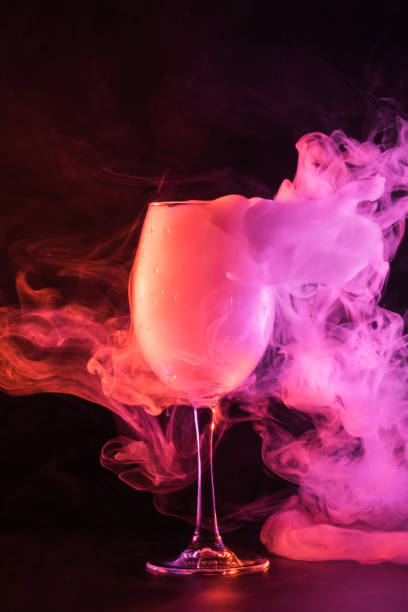 istock glass full of pink smoke on black background 977442344