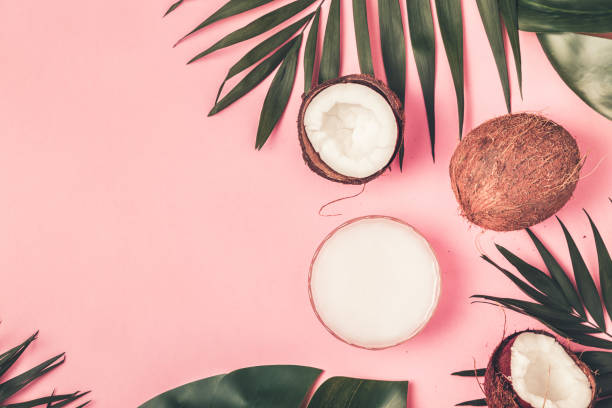 istock Coconut oil and coconuts on a background with tropical leaves 977442534