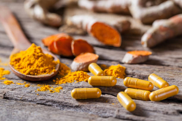 Turmeric powder, turmeric capsule and turmeric on wooden background Turmeric powder, turmeric capsule and turmeric on wooden background turmeric powder stock pictures, royalty-free photos & images