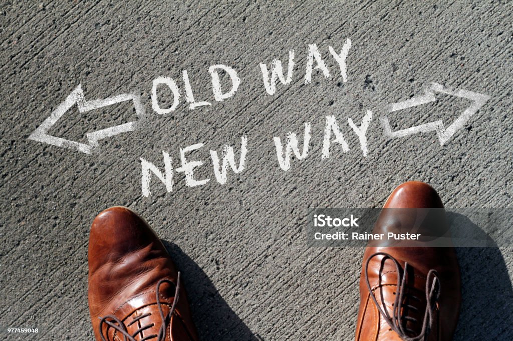 Decision time: Old Thinking or New Ways? A man at a junction has to decide between the old way and the new way. Breaking New Ground Stock Photo