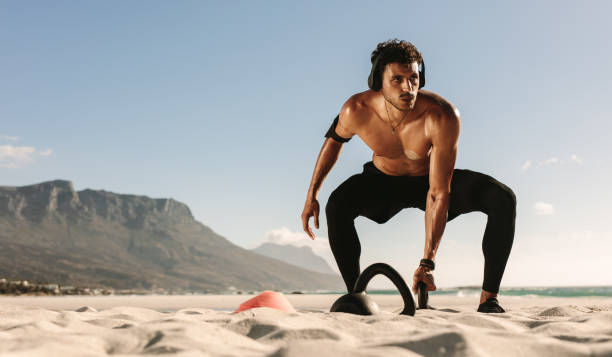 istock Man doing fitness training at the beach with kettlebells 977466758