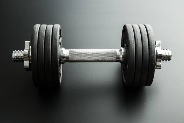 istock The metal dumbbell on black background. 977467362