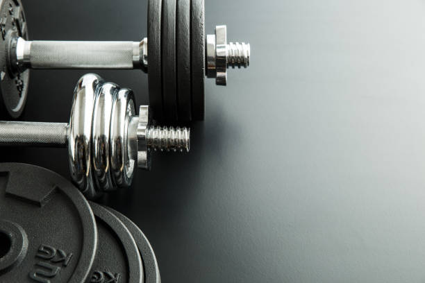 istock The metal dumbbell on black background. 977467430