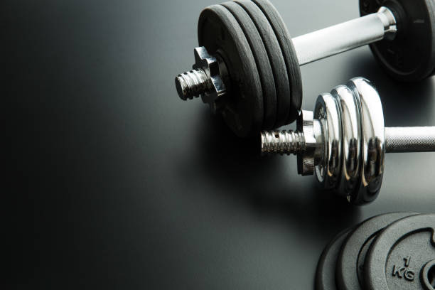 istock The metal dumbbell on black background. 977467510
