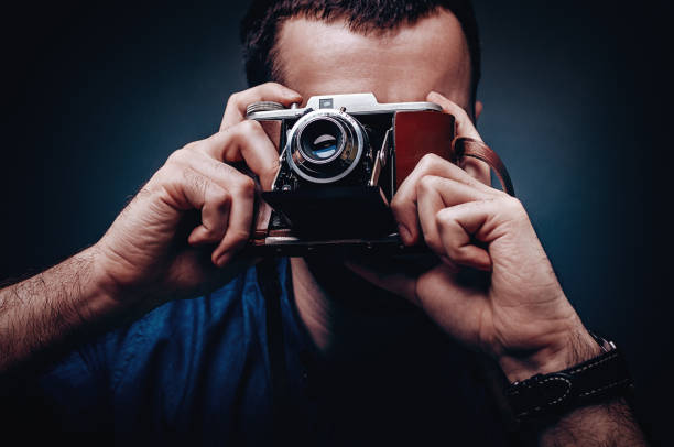 istock Photographer taking pictures with retro camera 977471598