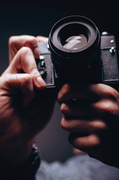 istock Male photographer holding analog camera exposing lens 977472420