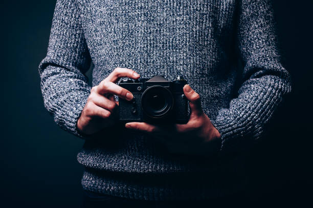 istock Photographer holding his finger on vintage camera shutter release button ready to shoot new photo 977472536