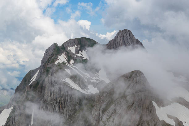 peak of natural Altmann mountain in clouds, Alpstein, clouds, blue sky