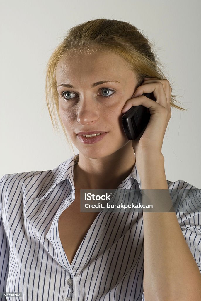 Businesswoman using mobile phone, smiling, close-up, portrait  25-29 Years Stock Photo