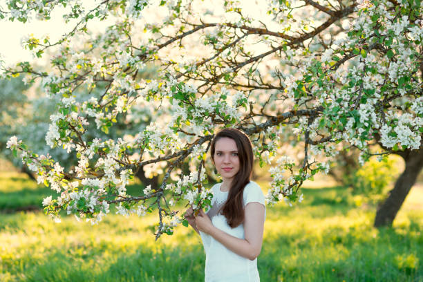 istock Beautiful woman in blossoming apple trees 977496146