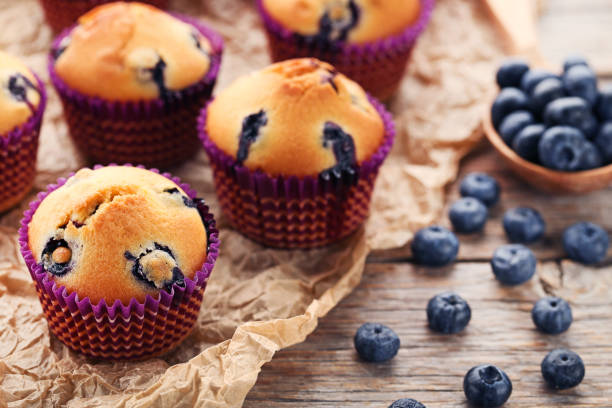 istock Sweet blueberry muffins on grey wooden table 977496654