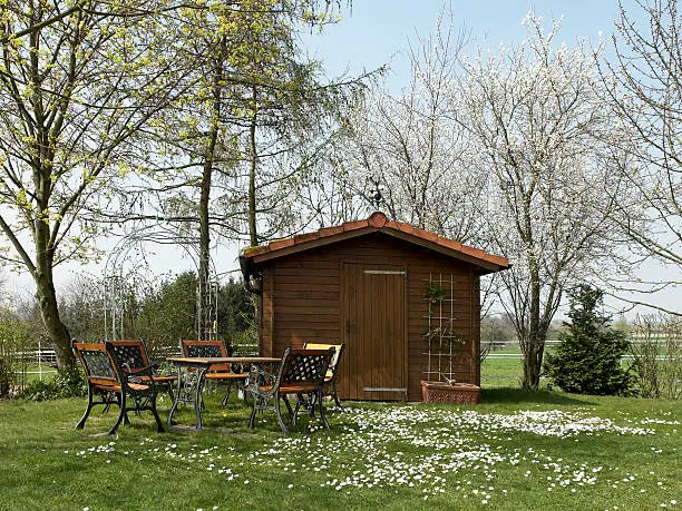 idyllic summerhouse and garden furniture at spring time