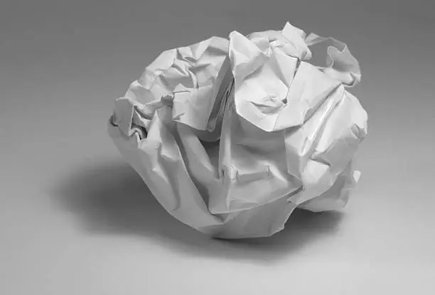 studio photography of a rumpled paper ball in grey back