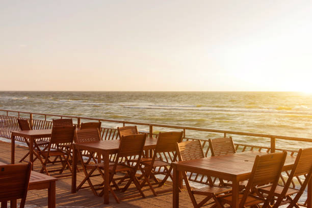 istock Summer empty open air restaraunt near sea at sunset 977540246