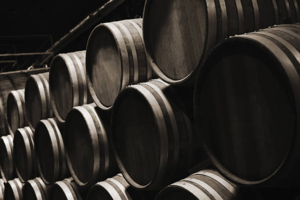 Wooden barrels in dark wine factory hall Wooden barrels in dark wine factory hall, close up photo monochrome with selective focus inkerman stock pictures, royalty-free photos & images