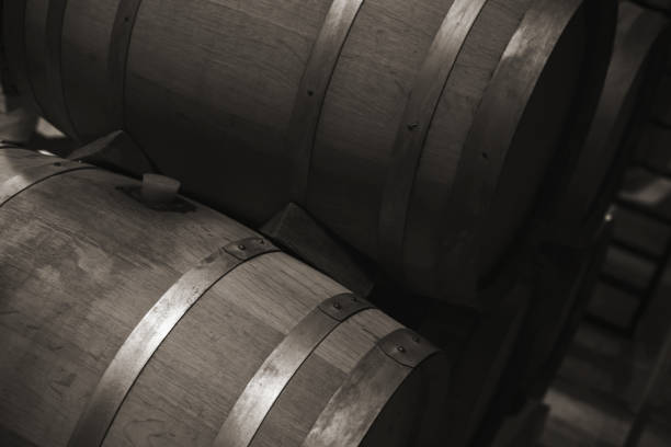 Wooden barrels with red wine in dark winery Wooden barrels with red wine in dark winery, monochrome photo with selective focus inkerman stock pictures, royalty-free photos & images