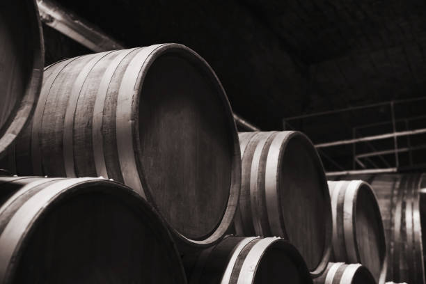 Round wooden barrels in dark winery Round wooden barrels in dark winery, close up monochrome photo with selective focus inkerman stock pictures, royalty-free photos & images