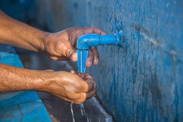 istock Man drinking water from a public tap 977566620