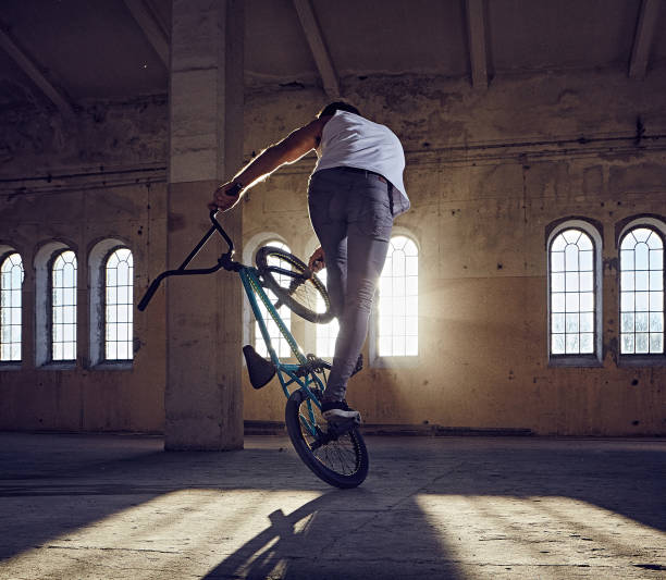 istock BMX stunt and jump riding in a hall with sunlight. 977580714
