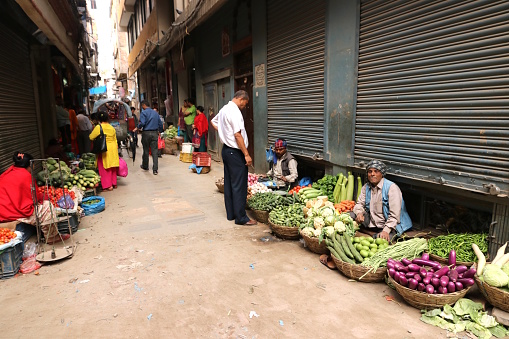Nepalese selling local vegetables in a street in Thamle, Kathmandu, Nepal, May 2018