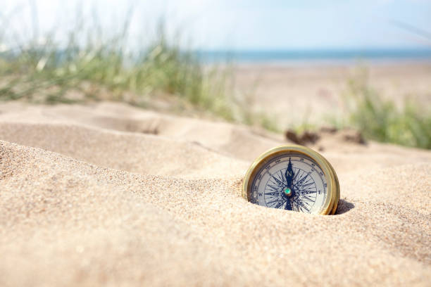 compás en la playa con arena y mar - compass exploration the way forward beach fotografías e imágenes de stock