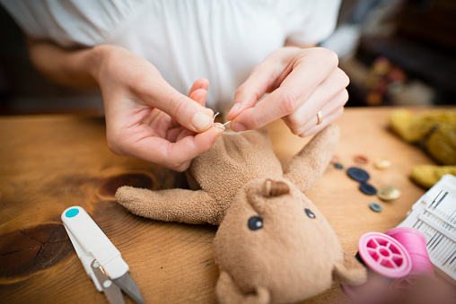 Hand to fix a stuffed toy bear