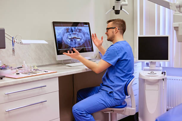 istock Dentist looking at teeth x-ray on the computer in a dentist office. 977594136