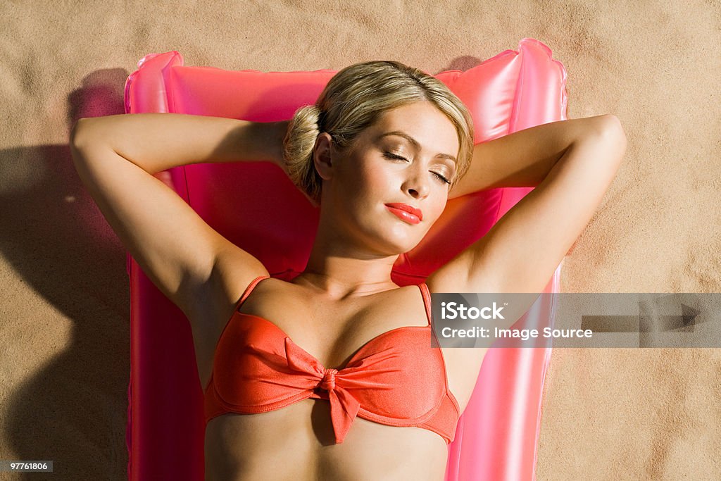 Giovane donna prendere il sole - Foto stock royalty-free di Capelli biondi