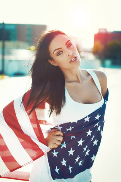 istock American sensual beauty covered by star spangled banner in sunset 977626664
