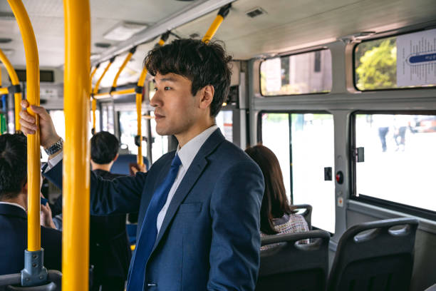 Businessman commuting by bus in Seoul - South Korea Businessman on the go in Seoul downtown commuting to work. South Korea lifestyle. seoul bus stock pictures, royalty-free photos & images