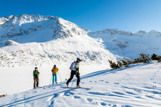 sciatori che camminano sulla neve fresca in 5 laghi della valle nella stagione invernale - carpathian mountain range adventure mountain peak mountain foto e immagini stock