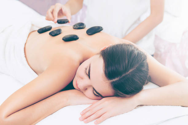 istock Hot stone massage treatment by therapist in spa. 977684366