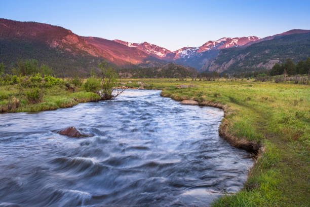 Sunlight hits the peaks of the mountain tops in Rocky Mountain National Park