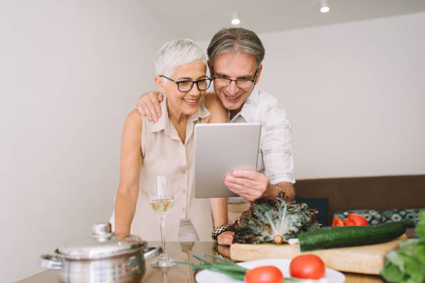 istock Happy couple hugging and looking at digital tablet 977688200