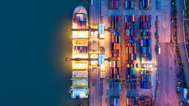 istock Container ship in export and import business and logistics. Shipping cargo to harbor by crane. Water transport International. Aerial view and top view. 977688694