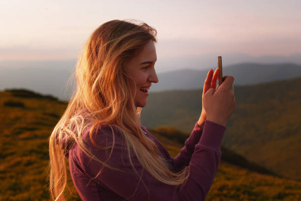 istock Young woman doing selfies on a phone in the mountains 977709622