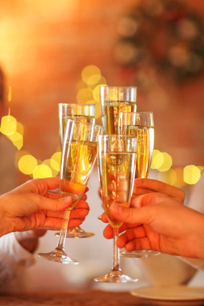 istock Champagne glasses in hands on golden background 977724474
