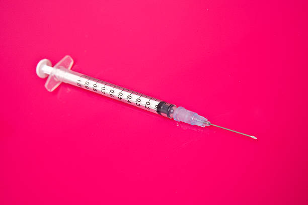 istock Hypodermic syringe on a pink background 97774624