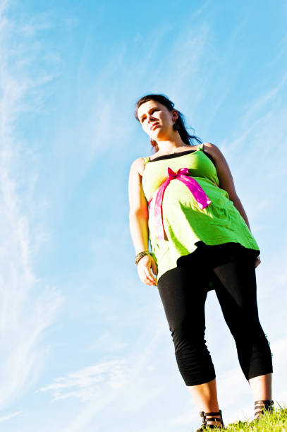 istock Pregnant Woman Posing In A Park 977747276