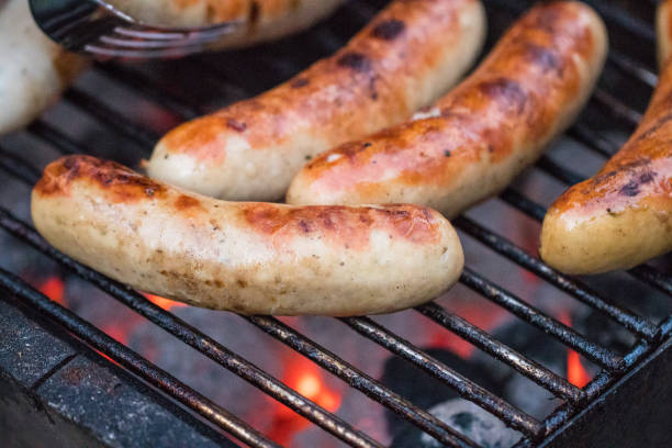 istock Grilling sausages on barbecue grill. Selective focus 977759398