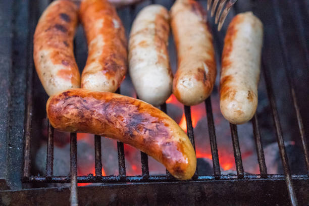 istock Grilling sausages on barbecue grill. Selective focus 977759430