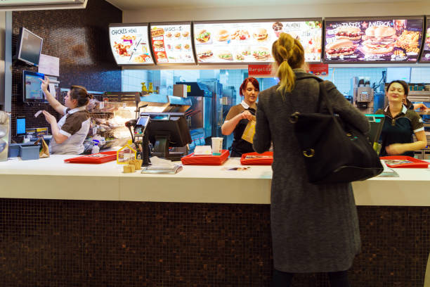 la jeune fille reçoit un ordre à l’intérieur de la mcdonald, munich, allemagne - quick burger photos et images de collection